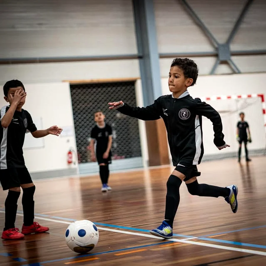 Un jeune joueur conduisant le ballon pendant un match.