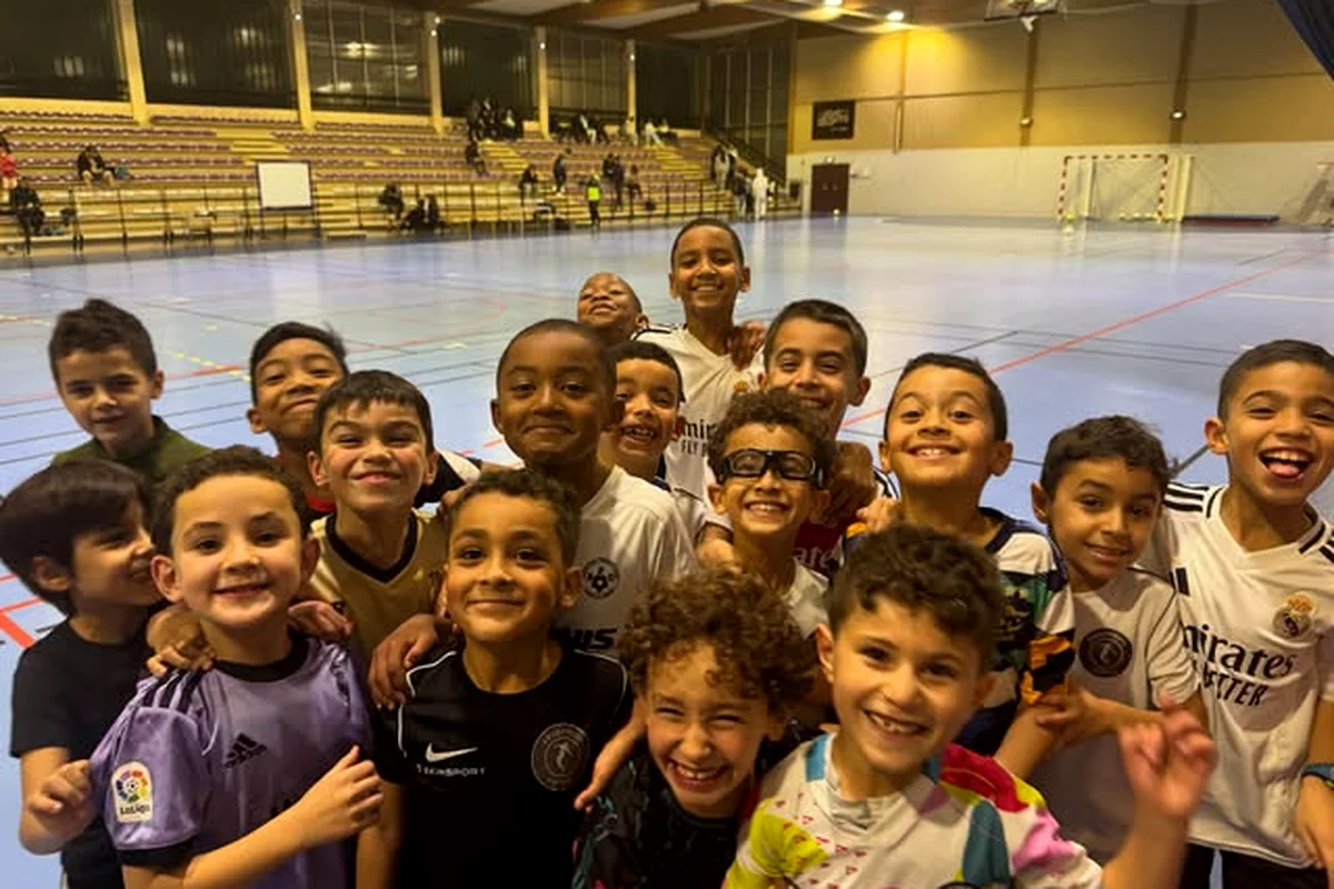 Un groupe de jeunes joueurs du club célébrant ensemble sur le terrain.